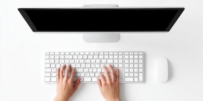 Person typing on computer keyboard at white desk photo