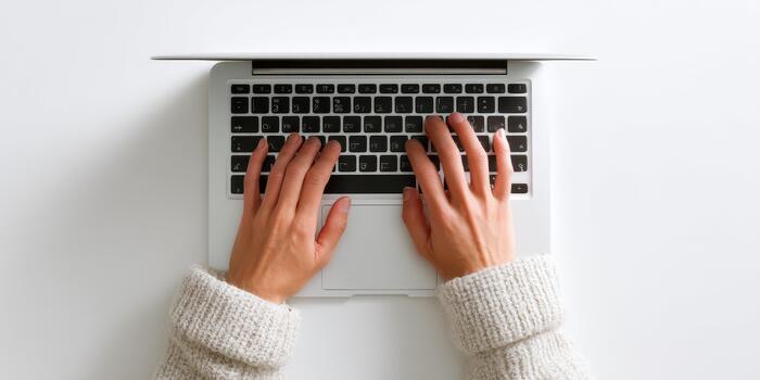 Human hands typing on laptop keyboard, top view photo