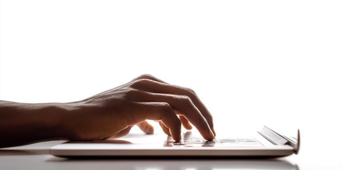 Hand typing on laptop keyboard against white background photo