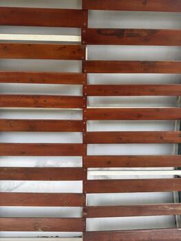 Parallel wooden slats with a warm finish and a sense of rustic privacy creating a visually photo