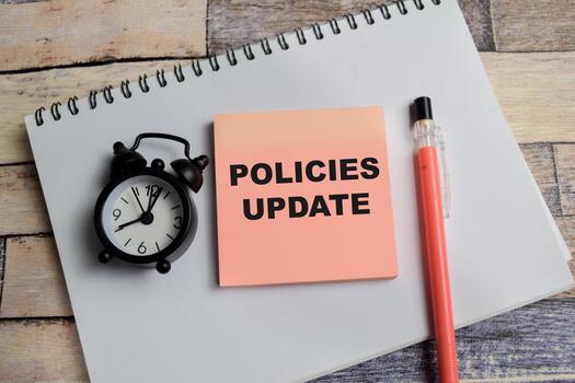 Concept of policies update write on sticky notes isolated on Wooden Table photo