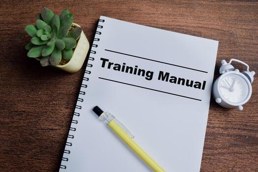 Concept of training manual write on book isolated on Wooden Table. photo