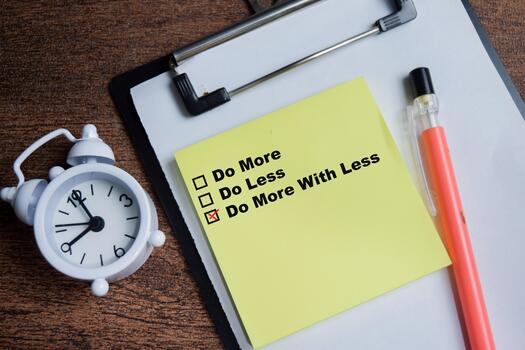 Concept of do more with less write on sticky notes isolated on Wooden Table. photo