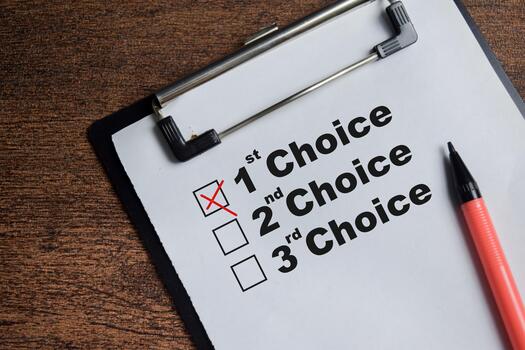 Concept of first choice opinion write on clipboard isolated on Wooden Table. photo