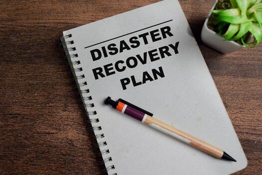 Concept of disaster recovery plan write on book isolated on Wooden Table. photo