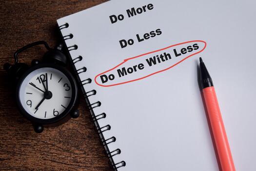 Concept of do more with less write on book isolated on Wooden Table. photo