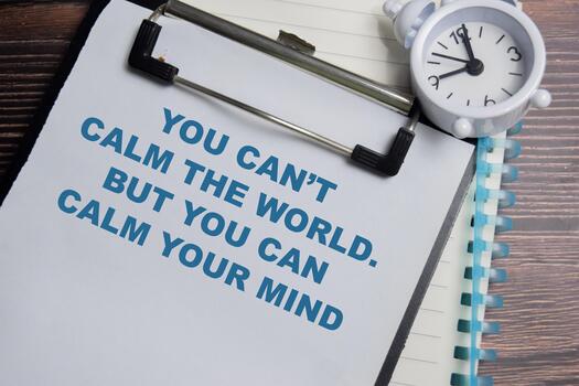 Concept of you can't calm the world. But you can calm your mind write on clipboard isolated on Wooden Table. photo