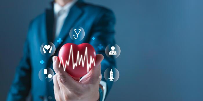 A person in a suit holds a heart with a pulse line overlay, surrounded by digital healthcare icons representing cardiac, medical, and health monitoring in a tech enhanced environment. photo