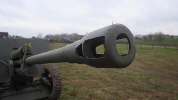 bred skott artilleri tunna munkorg pekande tvärs över Träning räckvidd, statisk transport på gräs, mulen himmel, taktisk beredskap vibb, besättning borra och demonstration sammanhang föreslog, texturerad video