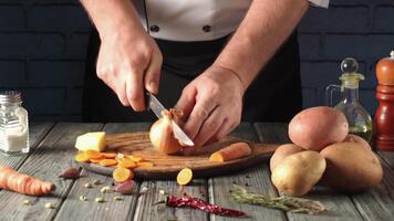 A chef skillfully slices a carrot and an onion while preparing fresh vegetables. Potatoes and herbs are neatly arranged nearby, emphasizing a focus on cooking. video
