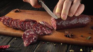 händer är skivning en botad korv på en trä- skärande styrelse. färgrik kryddor är spridning tvärs över de yta, skapande en värma, inbjudande kök atmosfär. de fokus är på de precision av skärande. video