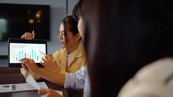 grupp av asiatisk motiverad yrkesverksamma engagerar i en strategisk möte, diskuterar företag tillväxt och uppkopplad strategier. de använda sig av tabletter och presentation till förbättra samarbete och aning delning. video