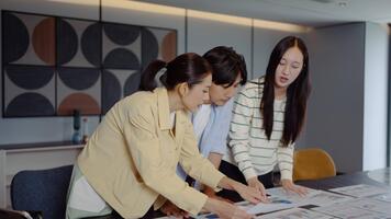 detta dynamisk asiatisk företag team av yrkesverksamma engagerar i en samarbete möte. analyserar dokument och strategisering för finansiell projekt i en samtida kontor miljö. video