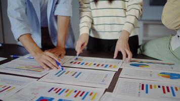 stänga upp händer av asiatisk ung företag yrkesverksamma förlova sig i en dynamisk brainstorming session. de samarbeta på strategier använder sig av diagram och papper. visa upp lagarbete. dagordning eller diagram papper video