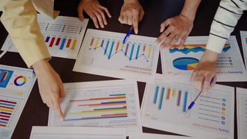 stänga upp händer av asiatisk ung företag yrkesverksamma förlova sig i en dynamisk brainstorming session. de samarbeta på strategier använder sig av diagram och papper, visa upp lagarbete. dagordning eller diagram papper video