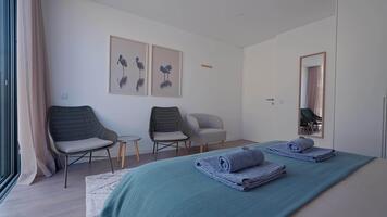 kricka och grå strö lägger till en pop- av Färg till detta minimalistisk hotell rum, terar korg- stolar, en stor spegel, och fågel tema konstverk, skapande en lugn och eleganta atmosfär video