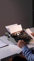 Vertical person is inserting a blank sheet of paper into an old manual typewriter, carefully preparing to compose a message, reflecting the classic process of written communication video