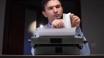 man läsning en brev, innehav den ovan ett gammal mekanisk skrivmaskin med papper, nedsänkning han själv i de skriven meddelande från en förgången epok av omtänksam kommunikation video