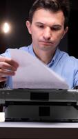 A man is looking at a piece of paper while using a typewriter video
