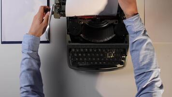 manos tracción un blanco sábana desde un antiguo máquina de escribir, cerca arriba parte superior ver transporte escribiendo, creatividad, edición, Fresco damas, comenzando terminado y Clásico oficina trabajo video