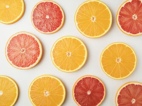 Fresh citrus slices arranged in a vibrant flat lay composition on a light surface photo