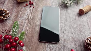 lento movimento superiore Visualizza di un' smartphone circondato di delicato festivo elementi mentre il telecamera si sposta senza intoppi per il giusto video