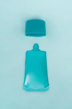 The sunscreen is displayed with its cap open on a bright blue background, creating a fresh and dynamic look photo