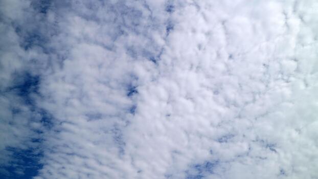 Bright cloudy sky with soft scattered white clouds photo