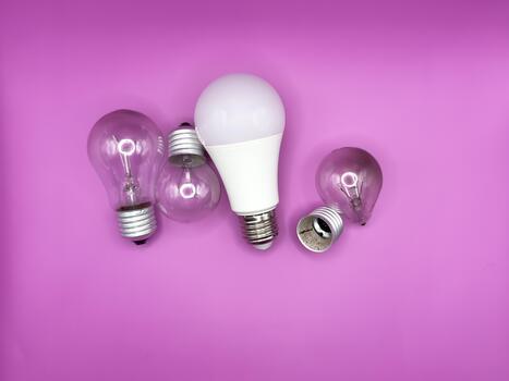 Modern LED lamp, saving electricity. Tungsten light bulb lamp. Non-working light bulb, broken light bulb. Concept of light and dark, idea, electricity copy space, flay lay, top view purple background. photo