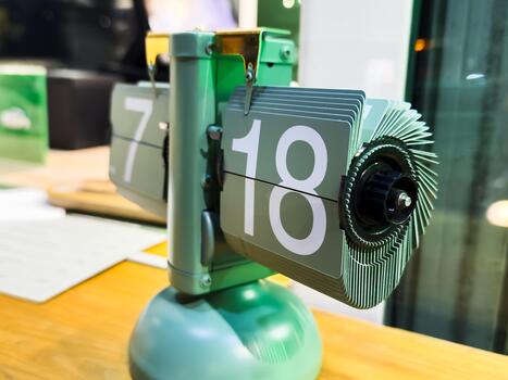 Green table clock with mechanical time change, hour and minute indication, modern clock, clock from the future photo