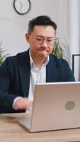 irritata stanco asiatico attività commerciale uomo mentre Lavorando su computer portatile, inaspettato in linea sito web problema, computer virus dati perdita di hacking. libero professionista sensazione pazzo di rotto taccuino a ufficio posto di lavoro video
