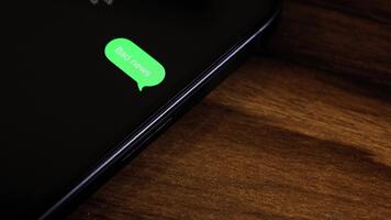 Close-up view of a smartphone screen showing an outgoing Bad News text message in a green bubble, captured as it sends with a smooth popup animation. video