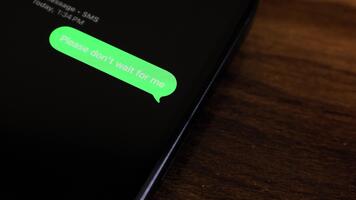 detailopname visie van een smartphone scherm tonen een uitgaand alstublieft niet doen wacht voor me breken omhoog thema tekst bericht in een groen bubbel net zo het verzendt. video