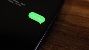 detailopname visie van een smartphone scherm tonen een uitgaand ik mevrouw u tekst bericht in een groen bubbel, gevangen genomen net zo het verzendt. video