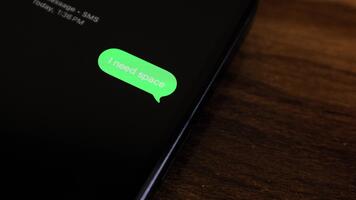 närbild se av en smartphone skärm som visar ett utgående jag behöver Plats text meddelande i en grön bubbla, fångad som den skickar med en slät dyka upp animation. video
