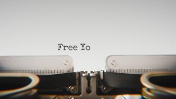 antiguo mecánico máquina de escribir mecanografía gratis tu mente en un cerca arriba vista, con metal letras sorprendentes el blanco papel. video