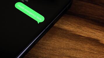 närbild se av en smartphone skärm som visar ett utgående hälsa nödsituation här text meddelande i en grön bubbla, fångad som den skickar med en slät dyka upp animation. video