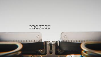 Old mechanical typewriter typing Project Plan in a close up view, with metal letters striking the white paper. video