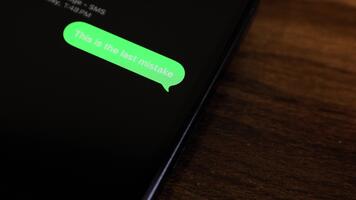 närbild se av en smartphone skärm som visar ett utgående detta är de sista misstag text meddelande i en grön bubbla, fångad som den skickar med en slät dyka upp animation. video