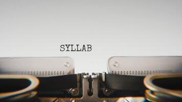 Old mechanical typewriter typing Syllabus in a close up view, with metal letters striking the white paper. video