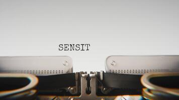 Old mechanical typewriter typing Sensitive Material in a close up view, with metal letters striking the white paper. video