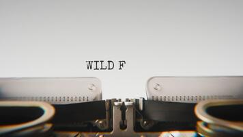 antiguo mecánico máquina de escribir mecanografía salvaje frontera en un cerca arriba vista, con metal letras sorprendentes el blanco papel. video