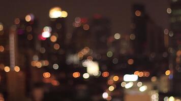 enterrar ver de alto rascacielos a noche. desenfocado ventanas y edificio parte superior luces crear un hermoso, soñador bokeh efecto. calentar luces video