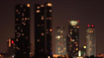 abstract view of tall skyscrapers at night. Defocused windows and building top lights create a beautiful, dreamy bokeh effect. The circular, warm lights video