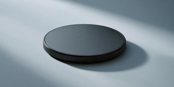Circular black object on a smooth surface in soft light photo
