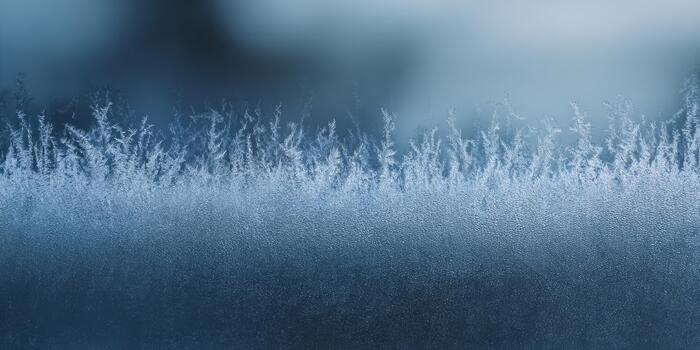 Frosty patterns form on glass during a cold winter morning photo