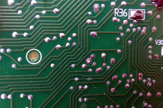 A close up of a green circuit board with some holes photo