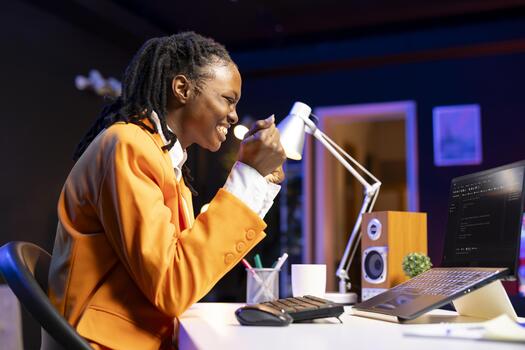 Happy developer at laptop programming, exuberating after writing lines of code, using development tools. Ecstatic woman in home office pleased after finishing debugging software on notebook photo