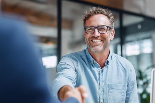 A man in glasses shaking hands with another man photo