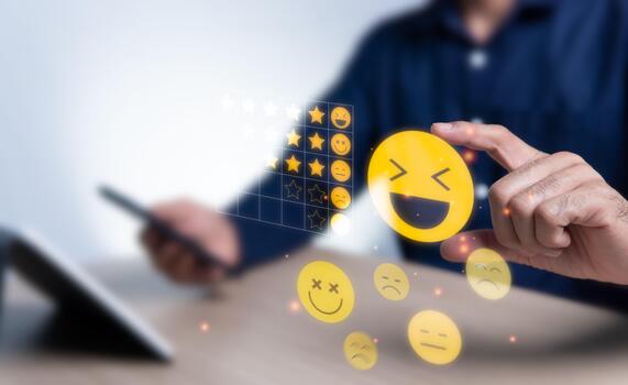 Customer satisfaction survey with face emoticons for comparison with a table from 1 star to 5 stars. Man hand holding a smiling face showing emotions to give a rating Soft blur background photo